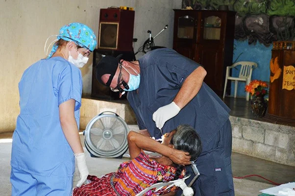 Dr. Dyer closely inspects a patient's mouth in Guatemala